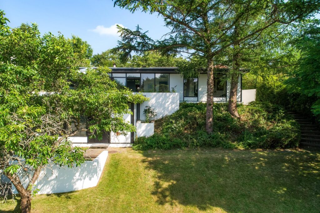 Japansk inspireret arkitekttegnet 60'er hus. Hvidt hus med store vinduer, arkitektoniske mesterværker