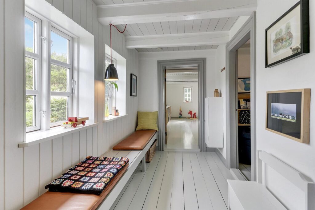 Hvidmalet paneler i bindingsværkhus