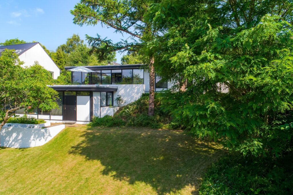 Japansk inspireret arkitekttegnet 60'er hus. Hvidt hus med store vinduer, arkitektoniske mesterværker
