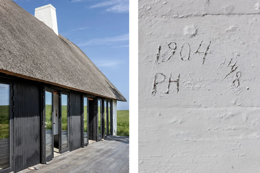 Arkitekttegnet fritidshus med stråtag og sortmalet træfacade